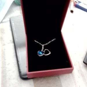 Silver chain with a blue heart shaped pendant in box